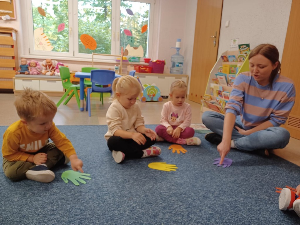 Dzieci siedza na dywanie i licza palce