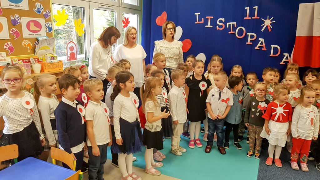 Dzieci ubrane elegancko spiewaja hymn polski razem z nauczycielkami