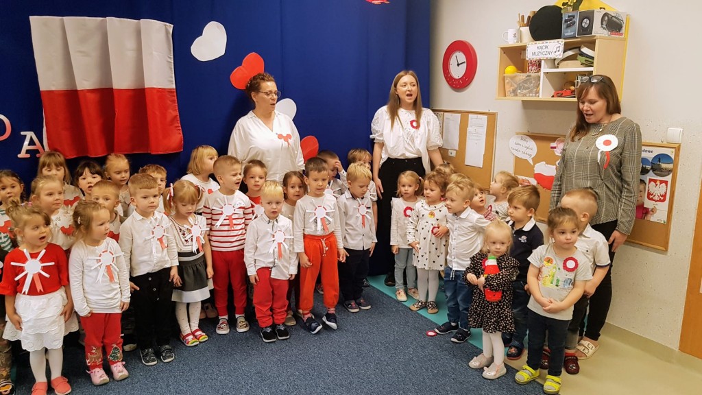 Przedszkolaki stoja na bacznosci i spiewaja hymn polski