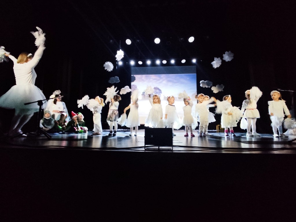 Dziewczynki ubrane na biale tancza do muzyki z pomponami