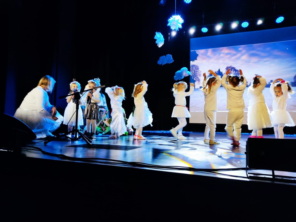 Dzieci spiewaja i tancza do piosenki dla rodzicow na scenie 