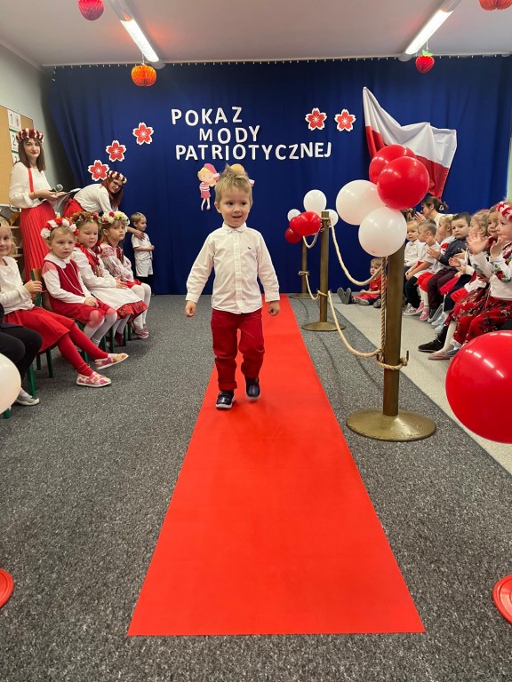 chlopiec idzie na pokazie mody patriotycznej